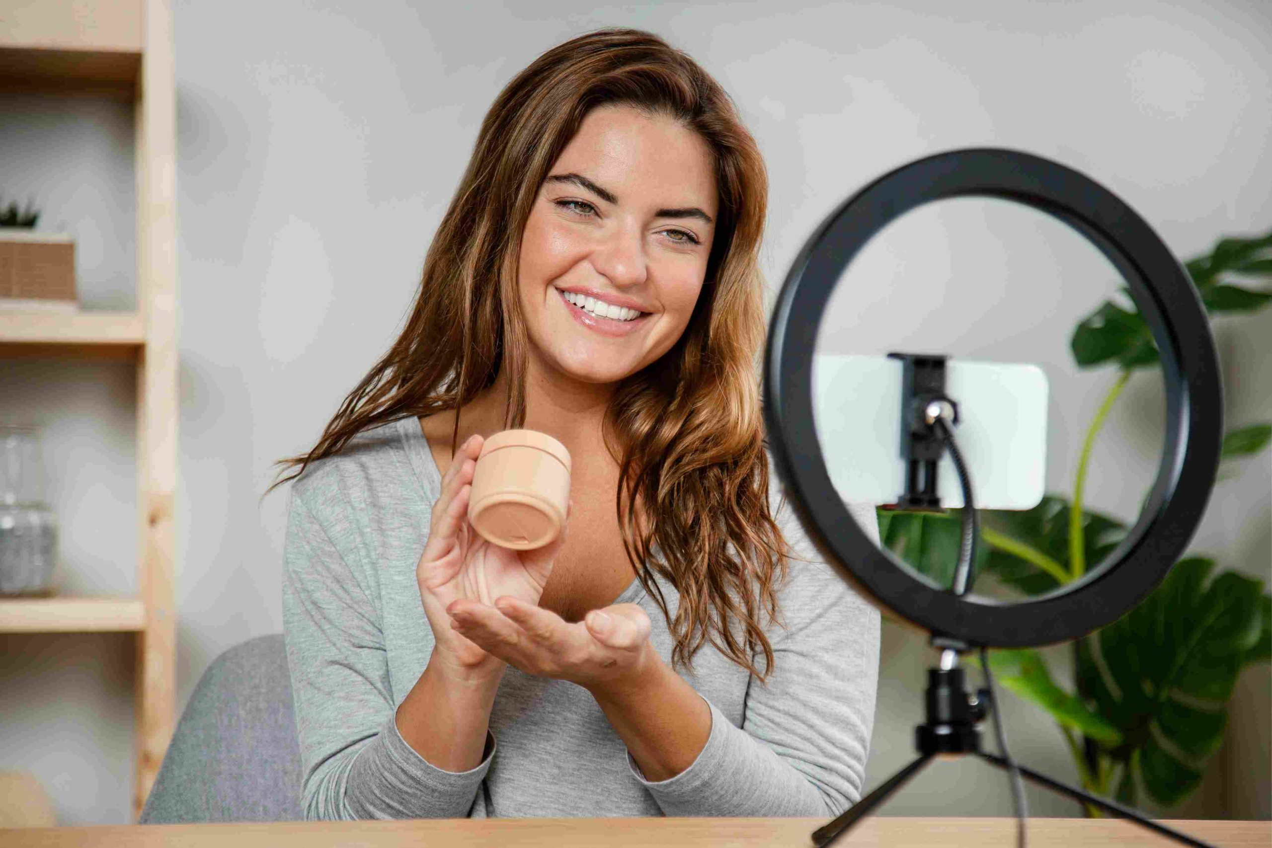Mujer haciendo un video de productos de belleza con un aro de luz - cómo hacer videos UGC