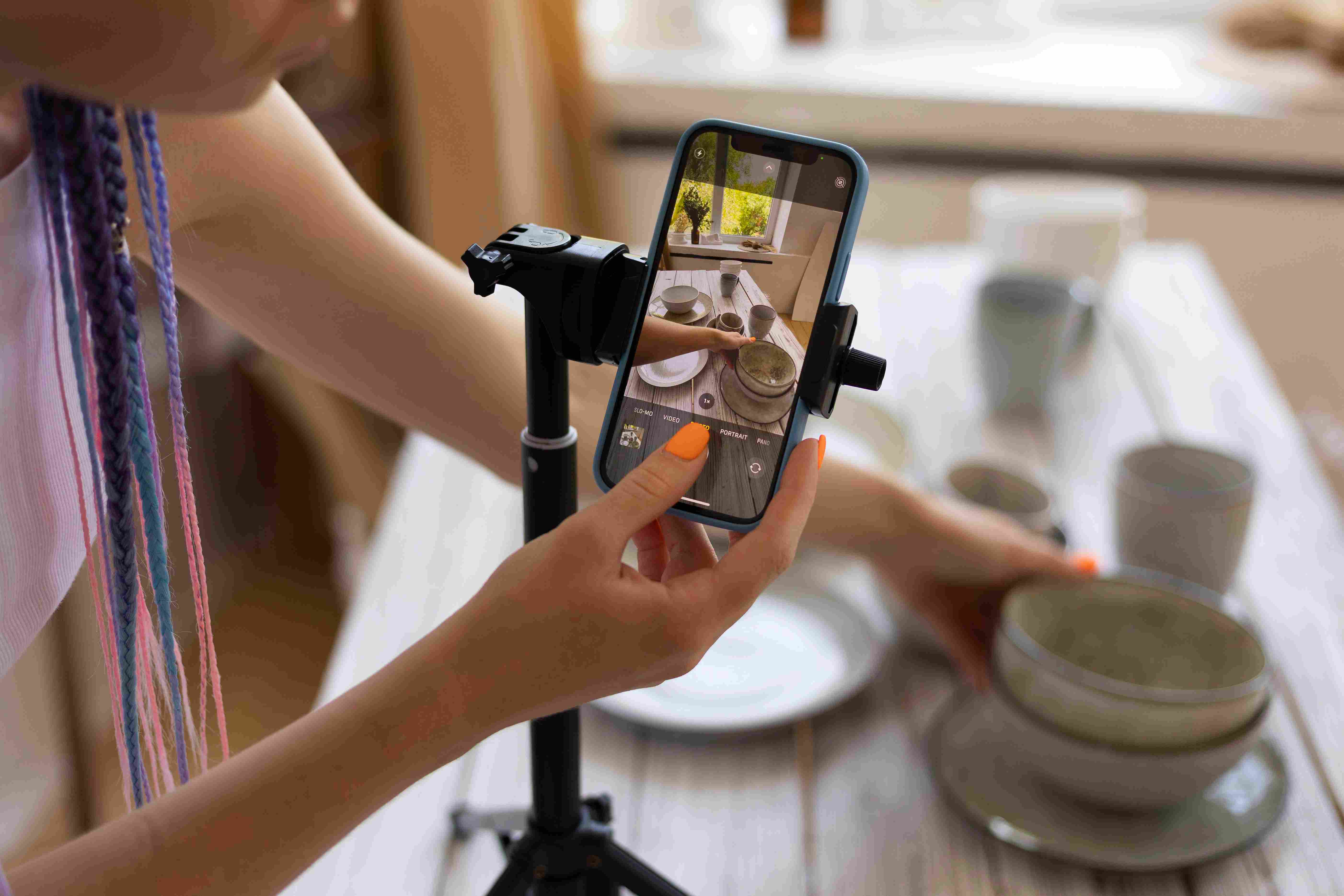 Mujer tomando fotos de utensilios de cocina de cerámica con su smartphone - UGC qué es